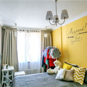 Uzraksts uz dzeltenās sienas guļamistabā