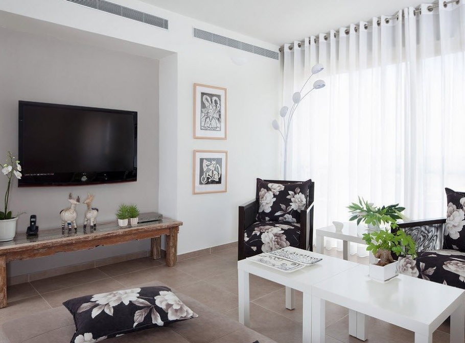 White curtains on the grommets in the living room of a two-room apartment