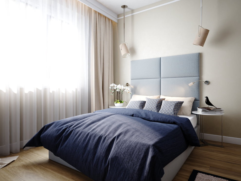 לוח אפור מעל המיטה באזור השינה של הדירה