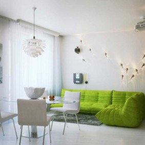 Žalia sofa didelėje gyvenamajame kambaryje