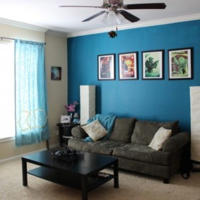 Pilka sofa palei mėlyną sieną
