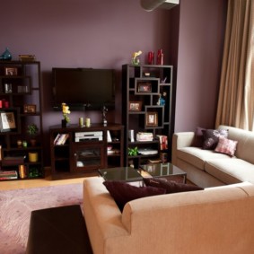 Kampinė sofa kambaryje su purpurinėmis sienomis