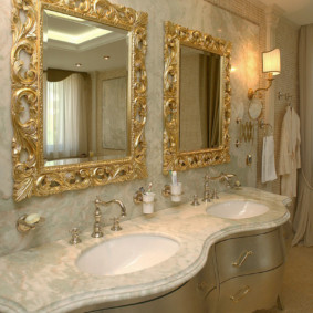 Spoguļi ar apzeltītiem rāmjiem vannas istabā