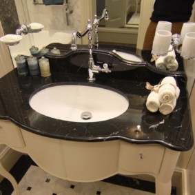 Lavabo avec un comptoir noir dans la salle de bain d'une maison privée