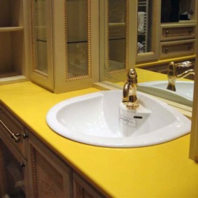 Sarı bir tezgah içinde beyaz lavabo