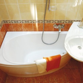 Oranžs dvielis vannas istabas pusē