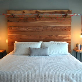 Light bulbs on red cords over a wooden bed