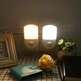 Compact nightlights in outlets on the bedroom wall