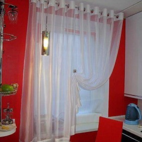 Rèm trắng trong nhà bếp với một bức tường màu đỏ