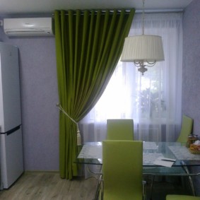 Green curtain on the kitchen window in a prefabricated house