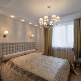 Chandelier above the double bed in the bedroom of the spouses
