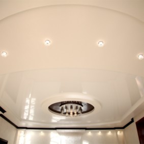 Glossy stretch ceiling with chandelier