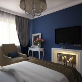 Küçük bir yatak odasında koyu mavi duvar