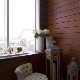 אגרטל עם פרחים טריים על אדן החלון של המרפסת