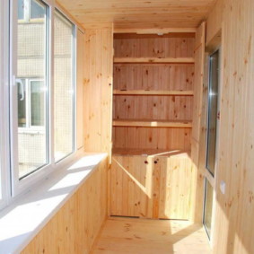 Wardrobe with wooden shelves on the loggias of a two-room apartment