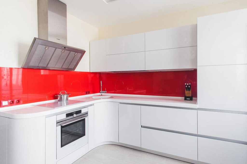 Sarkans priekšauts virtuvē ar stūra izlietni