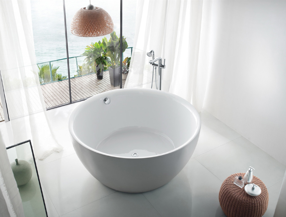 Round bathtub made of cast iron in front of a panoramic window