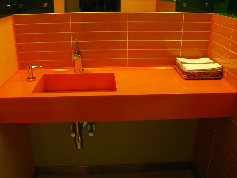 Orange tile above the countertop in the bathroom