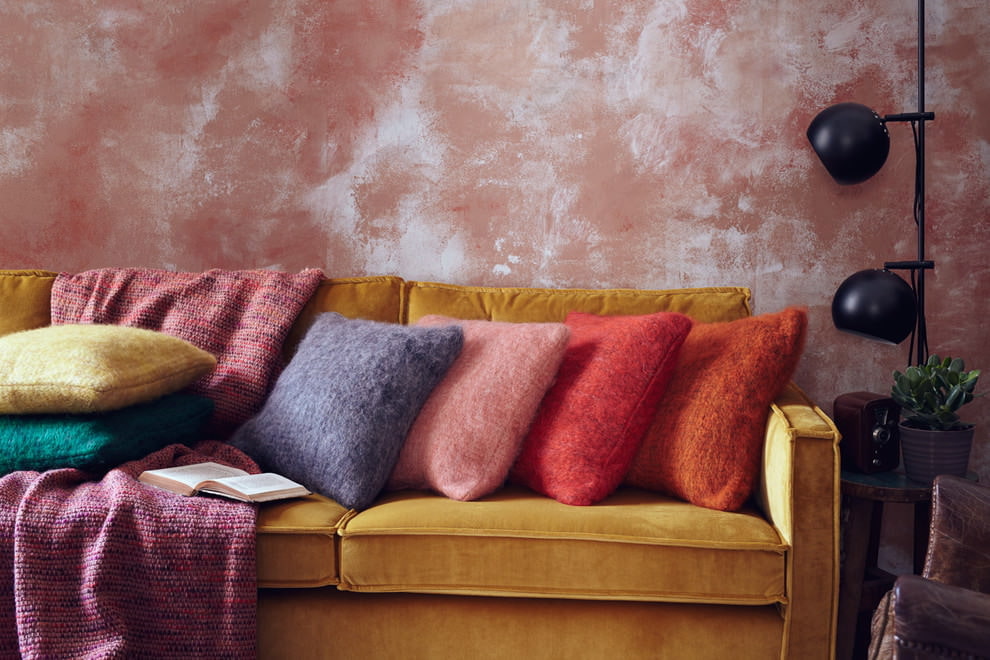 Garstyčių sofa gyvenamajame kambaryje su persikų sienomis