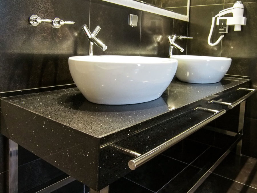 Mains courantes en acier inoxydable sur le comptoir en pierre de la salle de bain