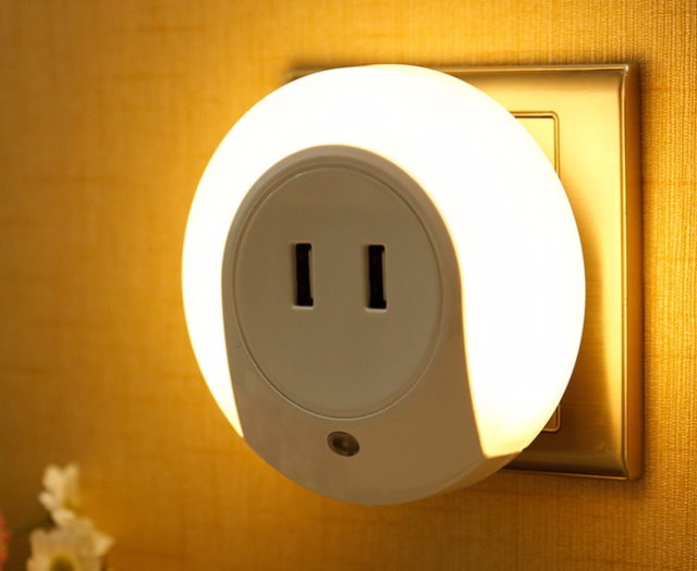 Night lamp with an adapter for a plug in the socket of a bedroom