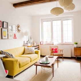 Canapea galbenă într-o cameră cu grinzi de lemn
