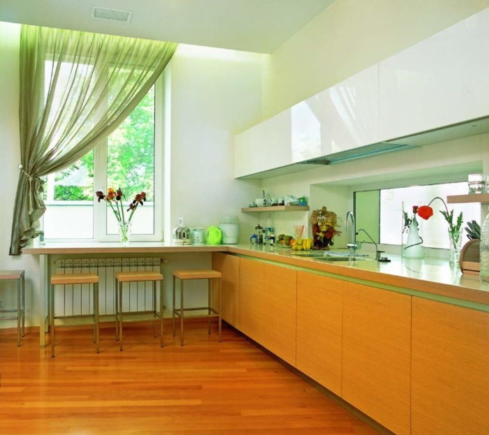 Gaiši zaļš aizkars vienā virtuves loga pusē