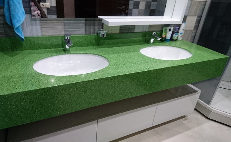 Green countertop in the bathroom with two washbasins