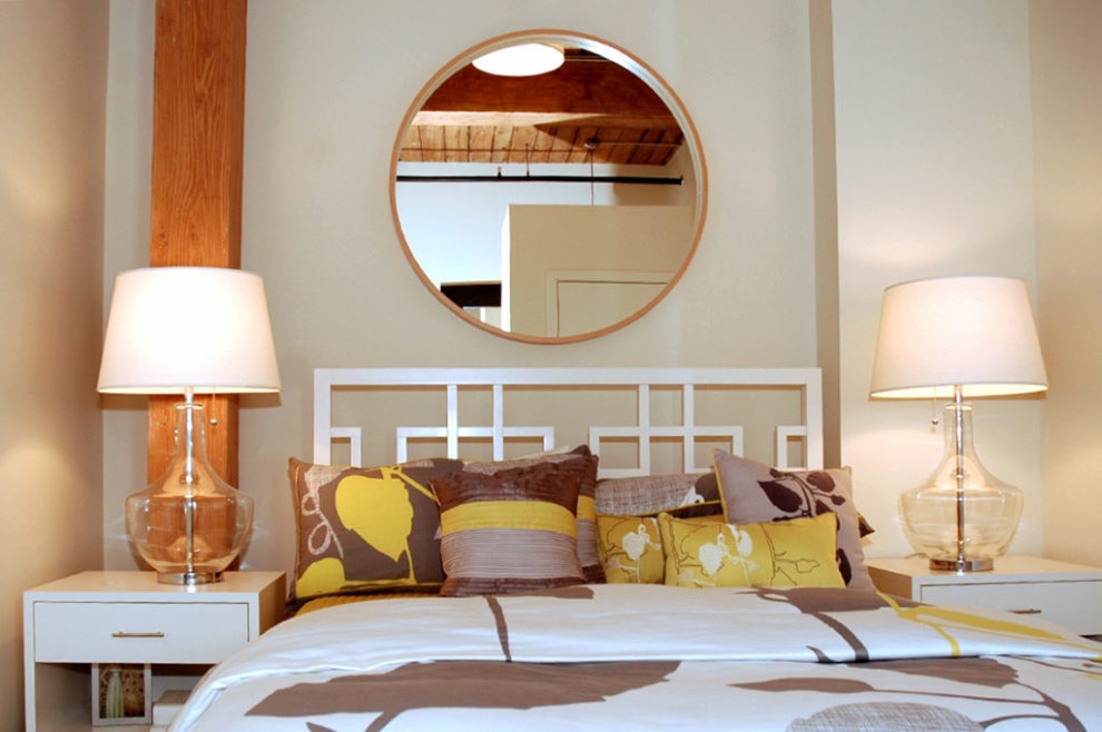 Round mirror over the head of the bed
