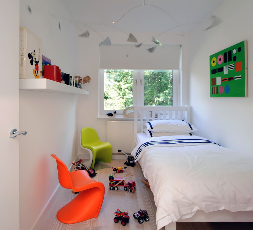 Chaises colorées dans une chambre avec un lit blanc