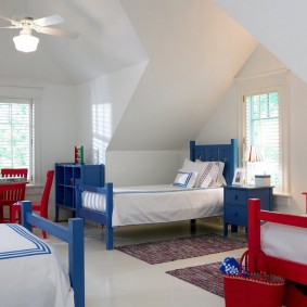 Geniş bir odada kırmızı ve mavi yataklar