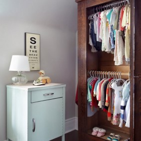 Vêtements pour enfants sur un cintre dans une armoire en bois