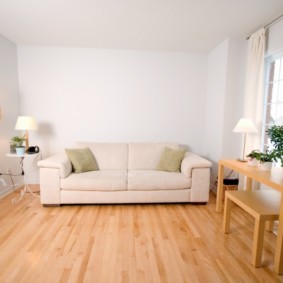 Balts dīvāns kvadrātveida formas zālē