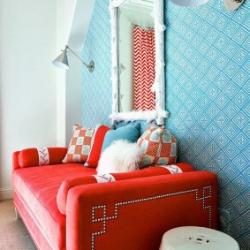 Canapé rouge dans le hall avec papier peint bleu