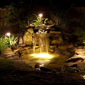 Lumières de jardin au bord d'un étang avec une cascade