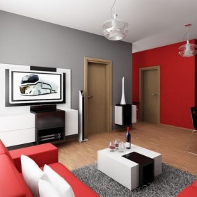غرفة معيشة باللون الأحمر والرمادي في شقة ذات لوحة منزل