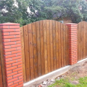 La combinaison d'une clôture en bois avec des piliers en brique