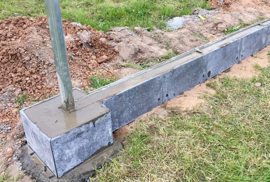 Fondation en béton pour une clôture avec des piliers en brique