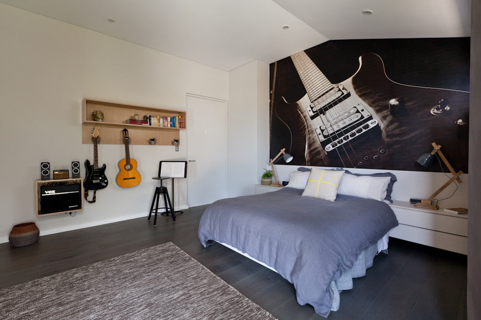 Genç bir müzik aşığı yatak odasında bir gitar ile duvar resmi