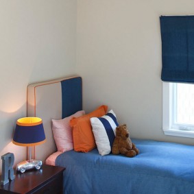 Mavi bir yatak üzerinde turuncu lamba