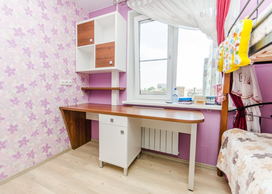 A desk under the windowsill in the girl's room