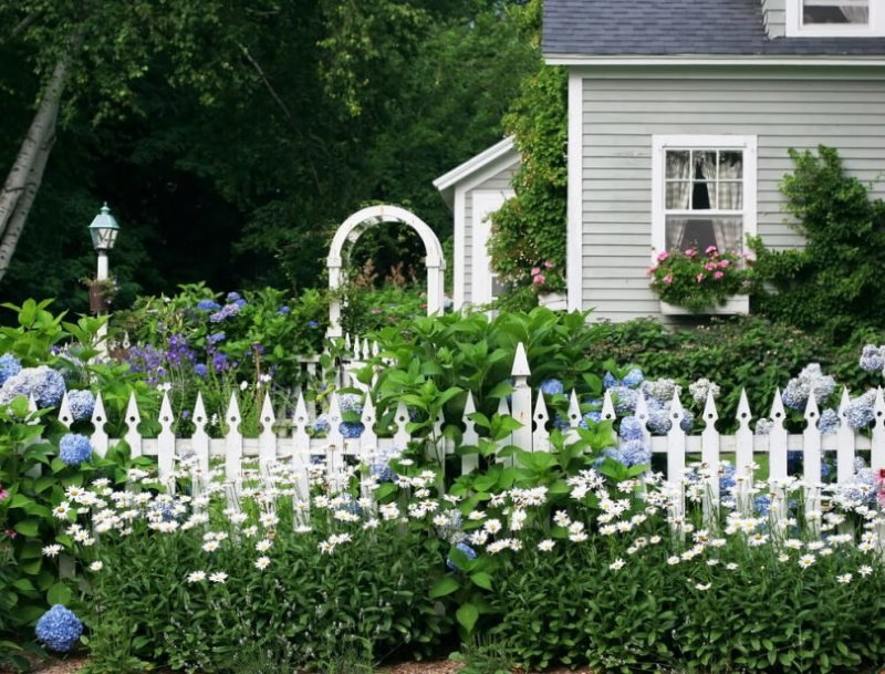 Clôture blanche dans le jardin devant le jardin
