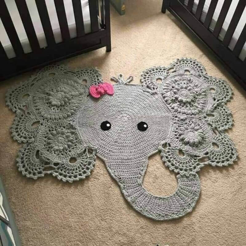 Bebek karyolası önünde bir fil şeklinde örme halı