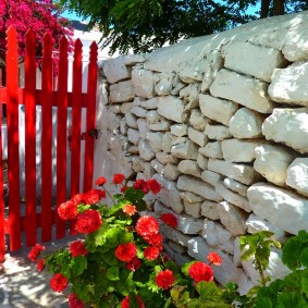 Porte rouge dans une clôture en pierre