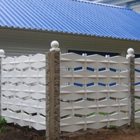 Boules blanches sur les piliers d'une clôture en béton