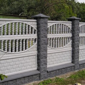 Gri sütunlar üzerinde beyaz beton çit bölümleri