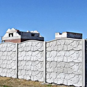 Longue clôture faite de sections de béton monolithiques