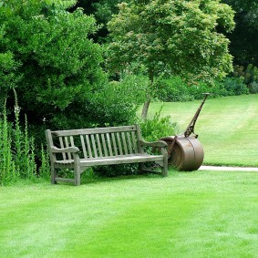 مقعد خشبي على قطعة أرض مع حديقة وعشب