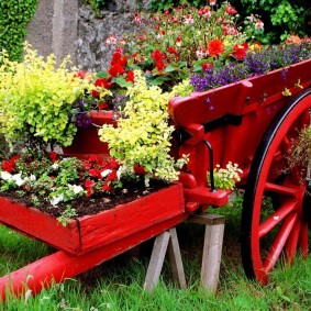 Vieux chariot comme parterre de fleurs