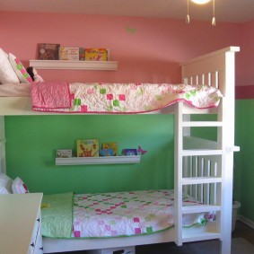 Murs rose-vert derrière un lit superposé